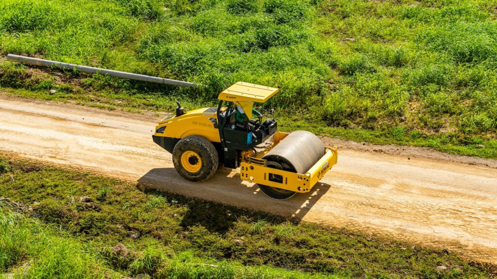 Man Driving Roller on Dirt Road