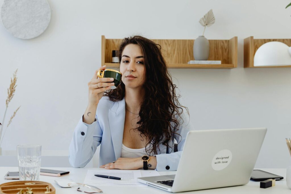 A Beautiful Woman Sitting while Holding a Cup of Coffee